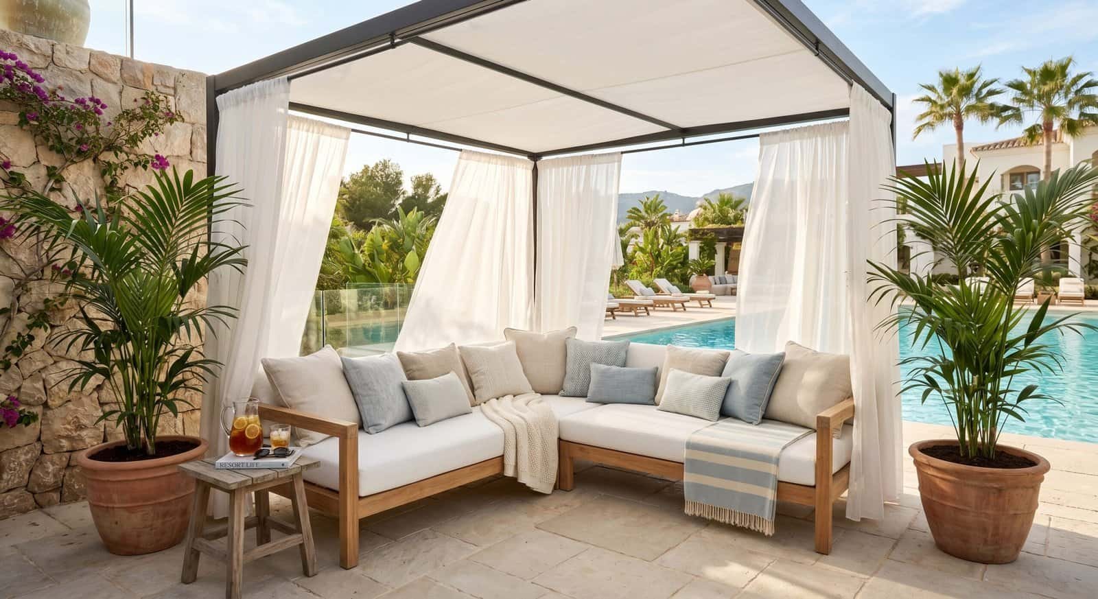 Outdoor patio with canopy, comfortable seating, and lush greenery for summer relaxation.